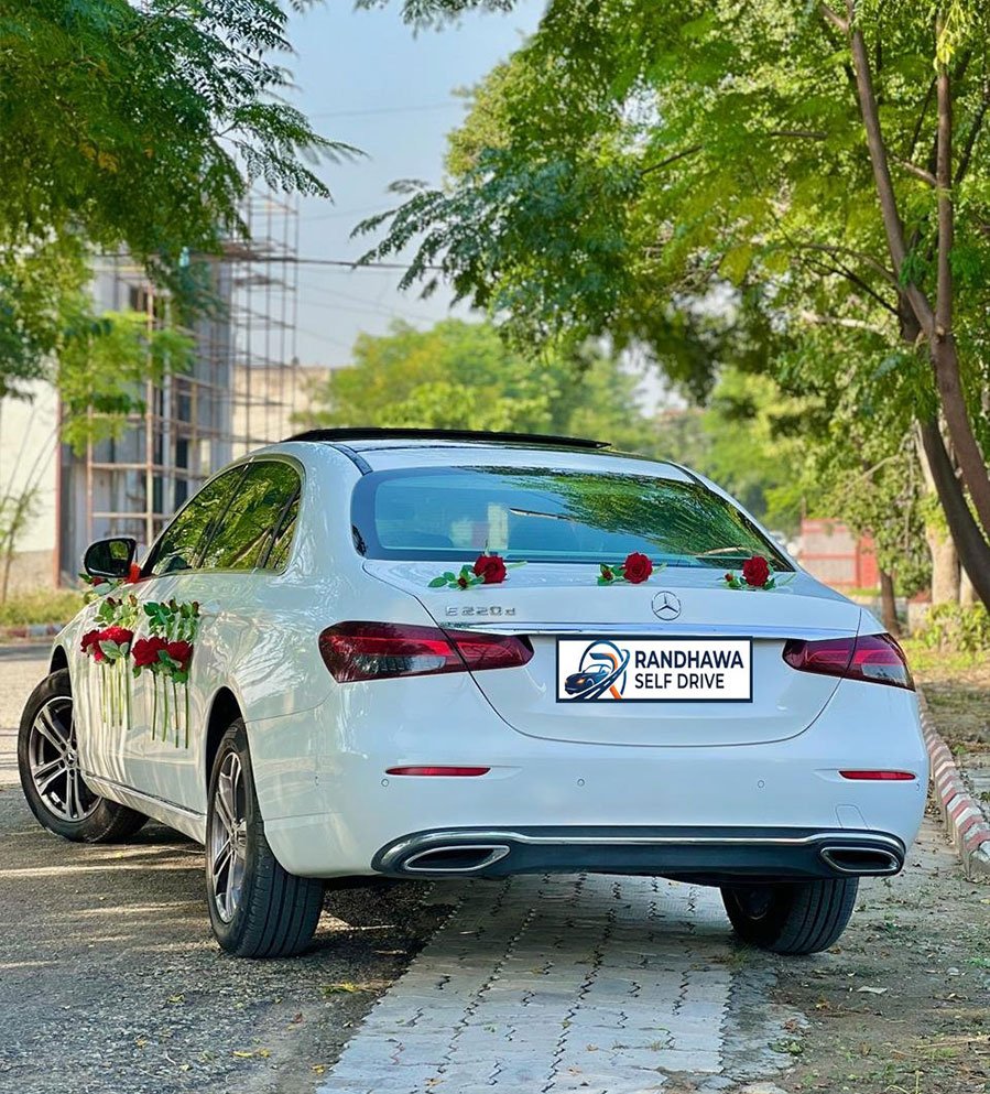 Rear view of the white Mercedes-Benz E-Class with roses on the boot lid